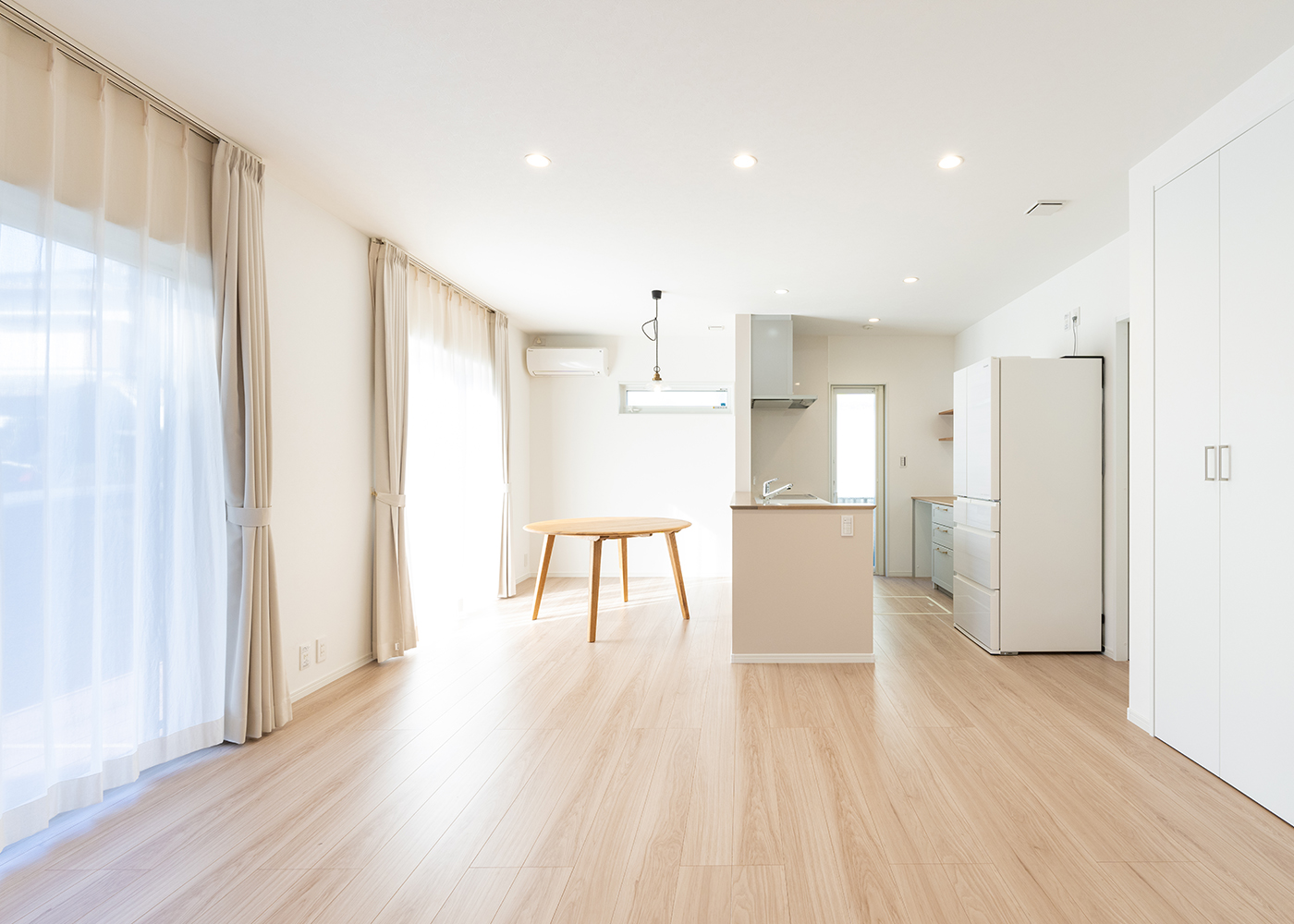 丸宗建設【デザイン住宅、収納力、省エネ】シンプル＆ナチュラルな雰囲気にコーディネートした17畳のLDK。大開口を開けるとウッドデッキとつながり、より開放感が生まれる