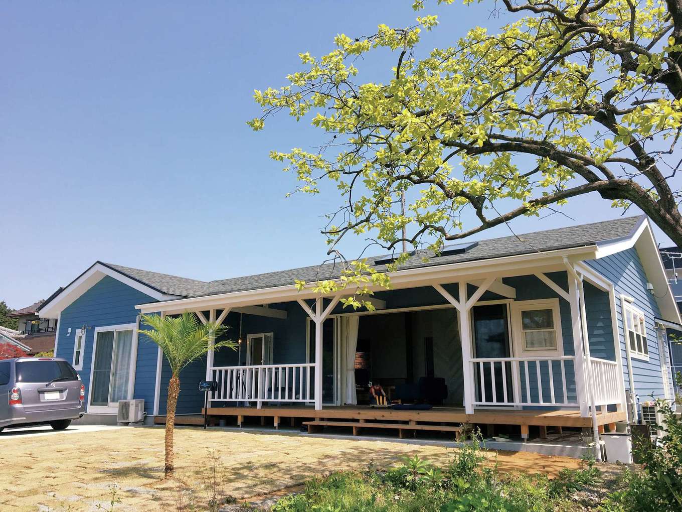 富士ホームズデザイン｜少しくすんだブルーの外壁、白い窓枠はご主人のリクエスト。増築したカバードポーチの屋根は、元の家の屋根から自然に折れる角度を付けてつなげてある。高いスキルがなくてはできない施工だ