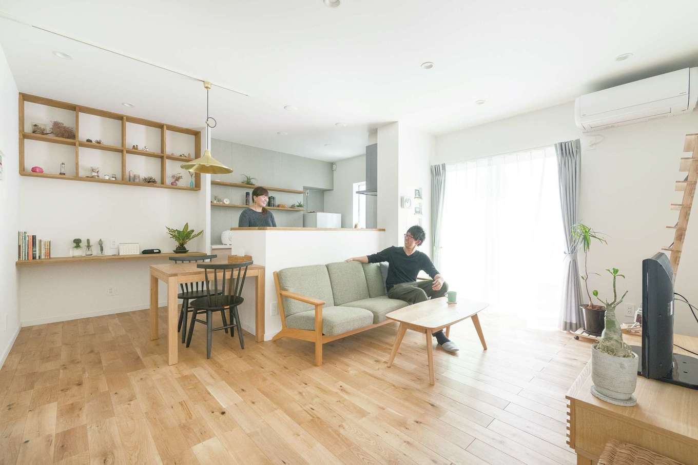 三和建設【デザイン住宅、趣味、間取り】床材は無垢材、壁は塗り壁。外観の色と呼応するように、ソファの生地やカーテンに用いたライトグレーをアクセントカラーにした空間は、好きなものだけを置きたいという奥さまの理想通り
