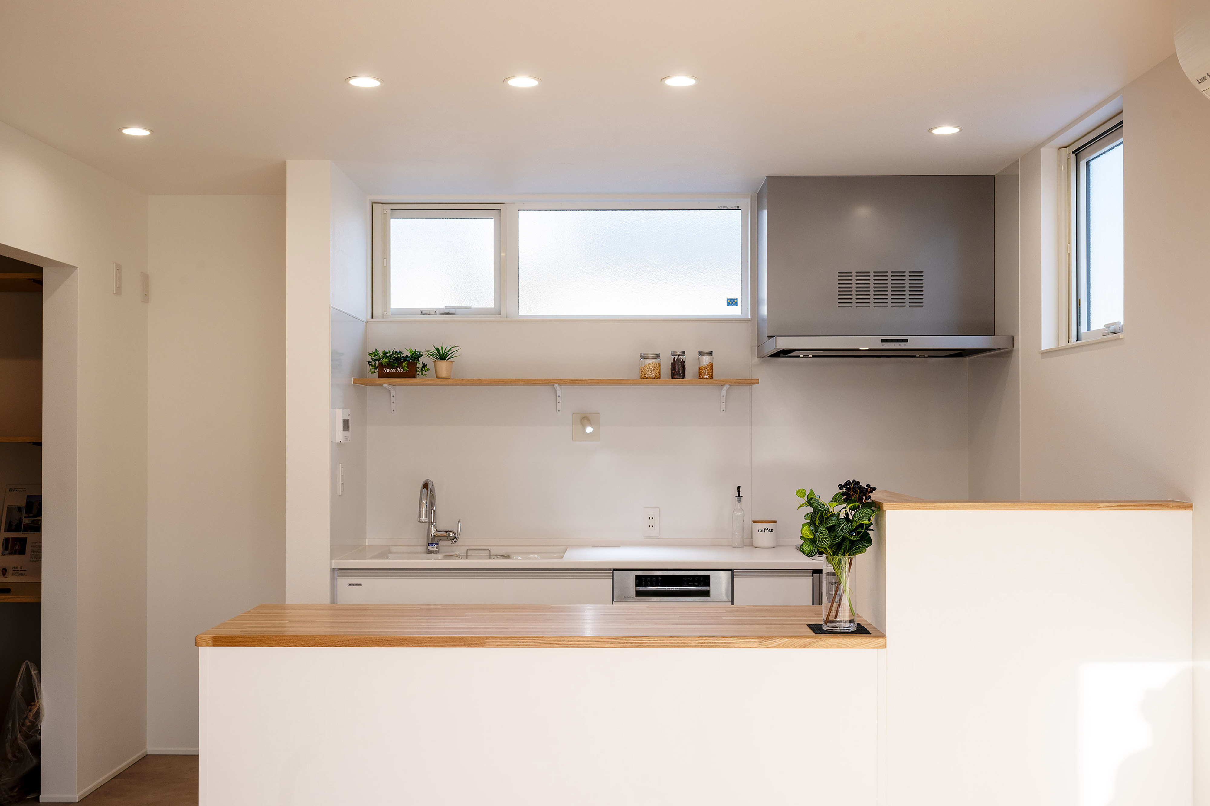 ハウスプラン（R＋house沼津・富士）【デザイン住宅、省エネ、建築家】パンづくりが趣味の奥さまは、壁付けキッチン+作業台のスタイルを選択した。食洗機はフロントオープンタイプを要望。作業台の下部は家電を収納できるようになっている