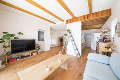 木の温もりが心地よい空間に、シャビ―シックなドアやインテリア小物、造作のテレビボードがしっくりと調和したリビング。等間隔に並んだ天井の化粧梁が空間の広がりを強調すると同時に、リビングのアクセント的な役割を果たしている