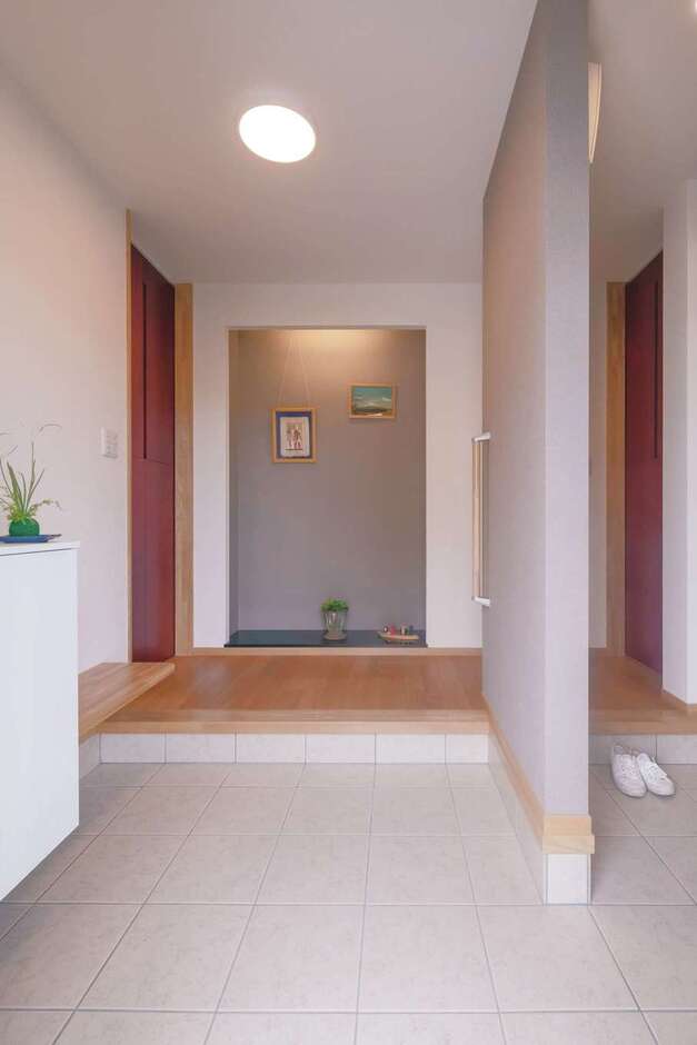 玄関は仕切りによって、穏やかに分割。正面にはもてなしの演出のためのスペースを用意