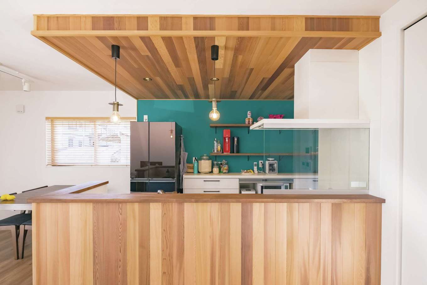 -delphi- デルフィ（藤井建築事務所） 【デザイン住宅、間取り、建築家】ターコイズブルーの壁紙が映えるキッチン右奥にはパントリーとして使える収納を設置