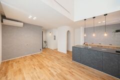 広々としたLDKで、モダンなデザインのキッチンが特徴的。オープンスペースのため、家族やゲストとのコミュニケーションが取りやすく、開放感を演出している。