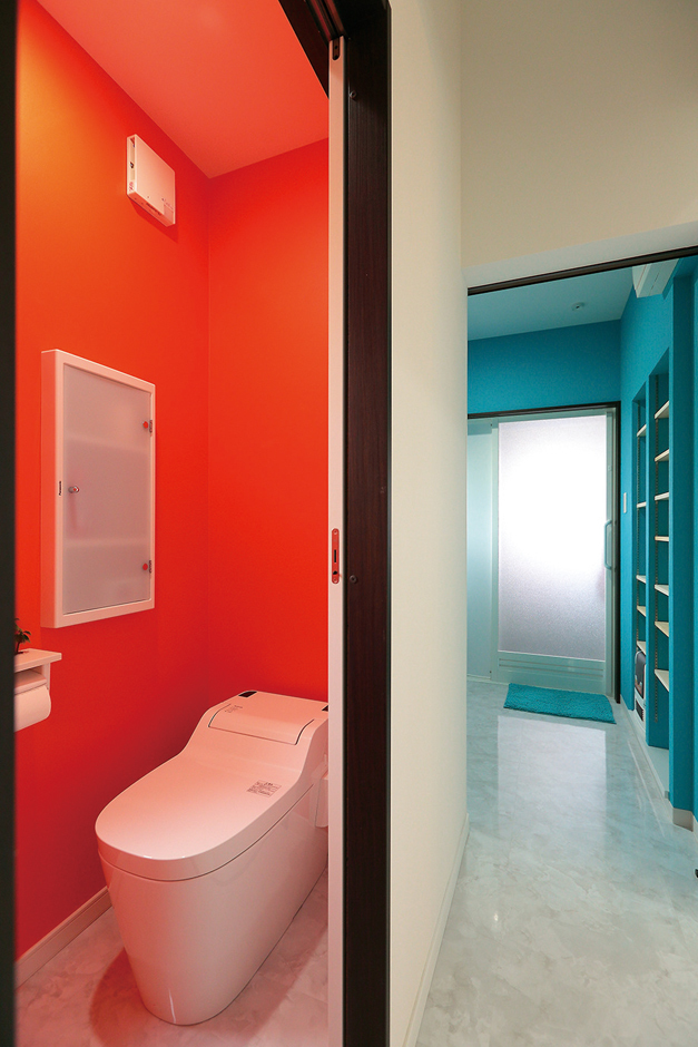 トイレはエルメスオレンジ、洗面は川をイメージしたブルー。ドアを開けた瞬間ハッとする鮮烈な色合わせ