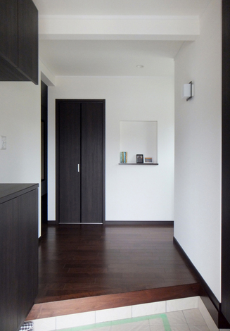 床や収納はダークブラウン、クロスはホワイトと、見た目がシンプルでスッキリとした玄関