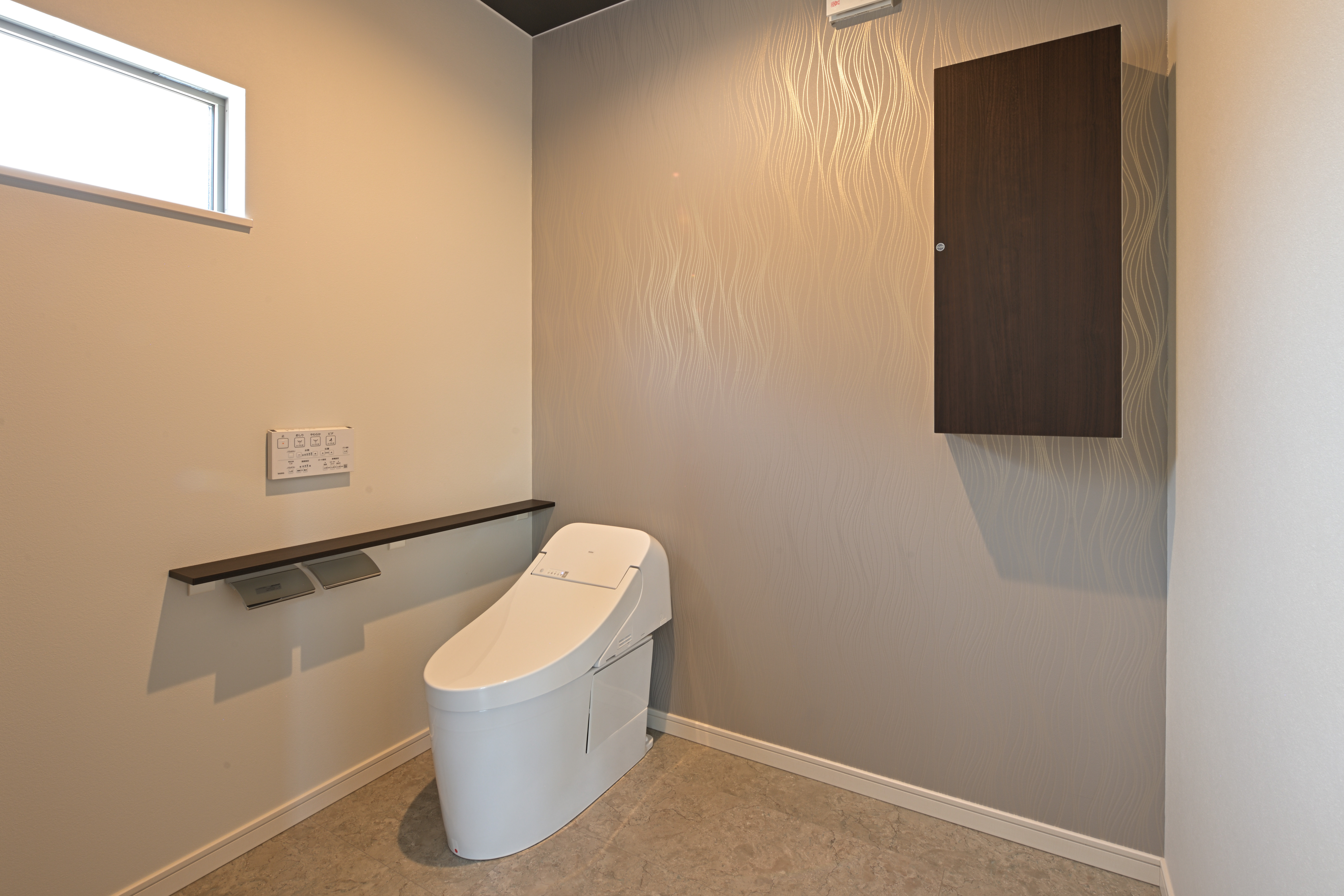 芳賀建工【子育て、収納力、間取り】車椅子のまま出入りできる約2.1畳の広いトイレ。照明とクロスのセレクトにもセンスを感じる