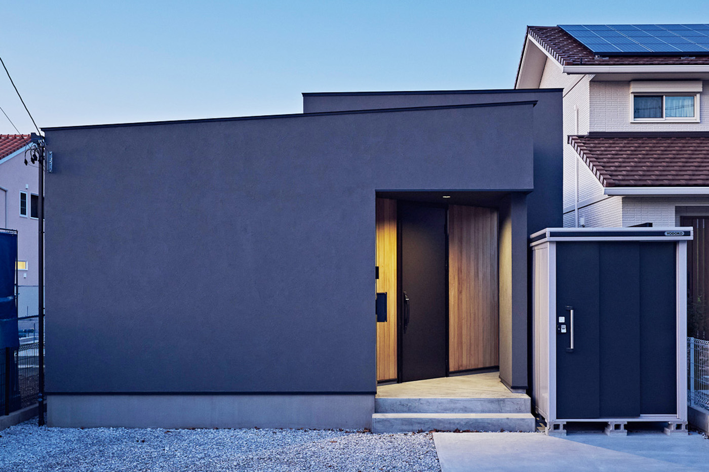 平屋建築ブルーハウス【和風、建築家、平屋】塗り壁や板張りの壁の素材感を生かした平屋の外観。奥行きのある玄関ポーチが、どことなく京の町屋を思わせる印象