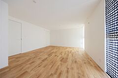 明るく広々としたLDK空間。ナチュラルな木目調のフローリングが温かみを演出し、シンプルなインテリアが生活のしやすさを強調している。
