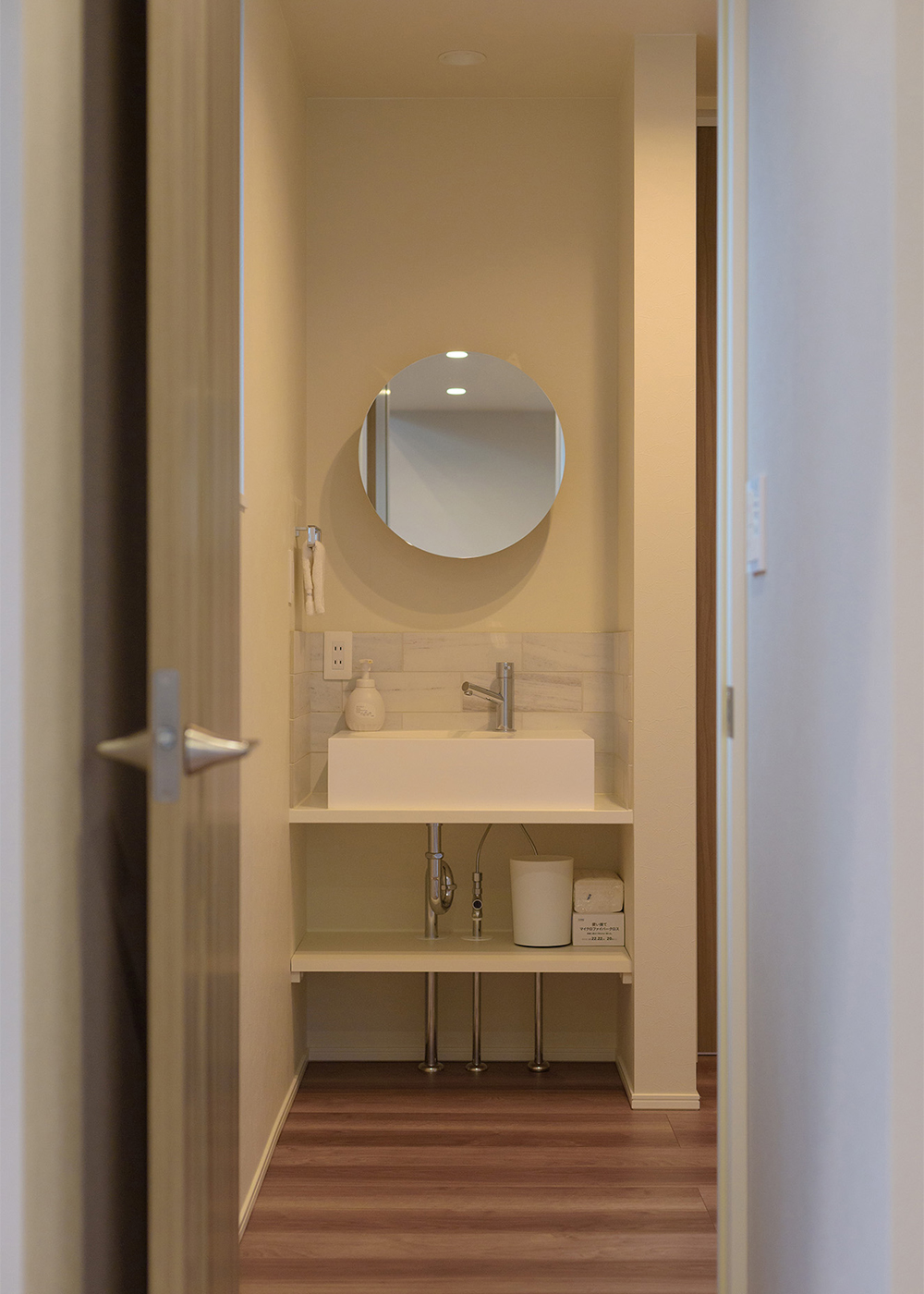 KAZA DESIGN【間取り、屋上バルコニー、インテリア】２階のトイレ横には造作の手洗いを設置。丸いミラーが可愛らしい。セカンド洗面ゆえ、見た目も重視してデザインした