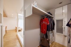 使いやすさを重視したクローゼット。服やバッグを効率よく収納するためのスペースが確保されており、隣接するリビングとランドリースペースへのアクセスもスムーズで便利。