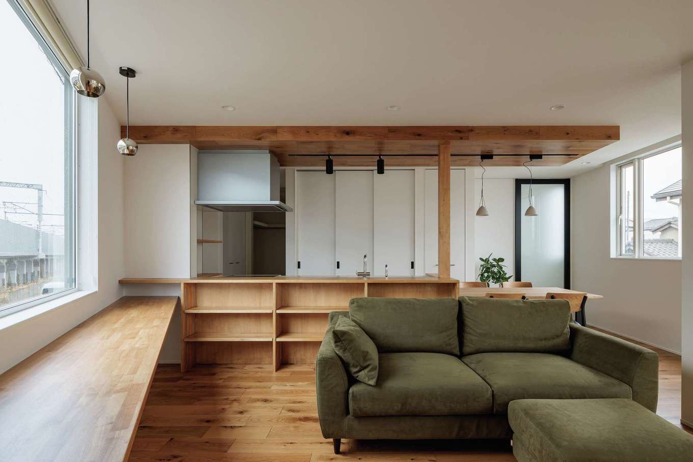 tact design firm【デザイン住宅、狭小住宅、間取り】視線を避け、採光と通風を考えてLDKを2階に配置。長いカウンター、キッチンの背面収納を無垢材で造作し、空間に統一感を出した。センスのいいソファや照明器具は『タクト』の大石さんがショールームや家具SHOPに同行してセレクトしてくれた