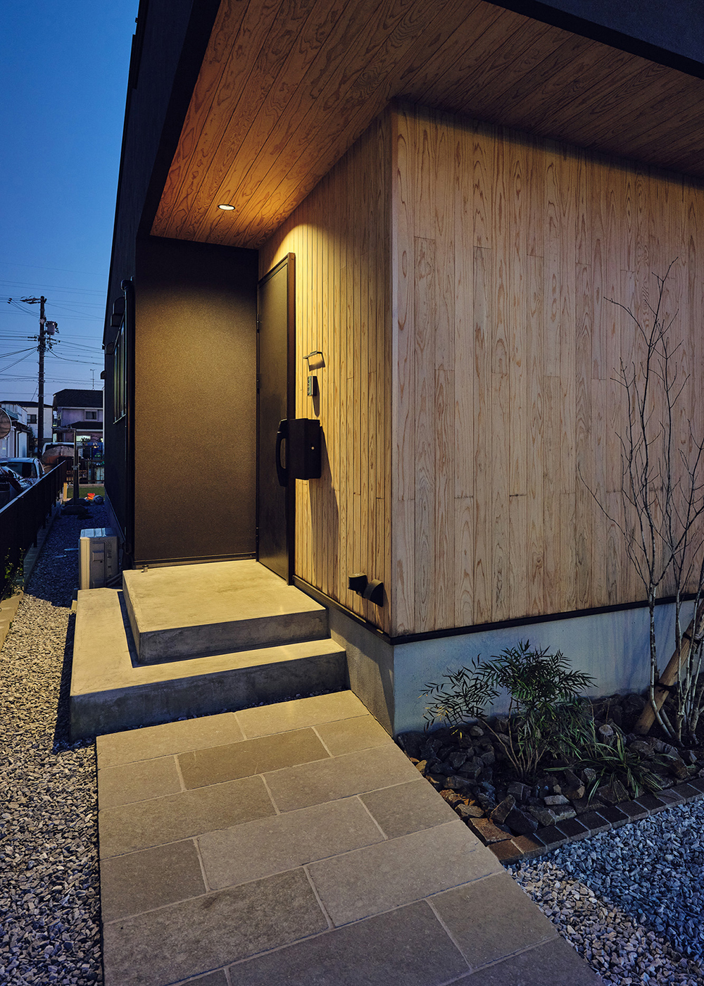 平屋建築ブルーハウス【デザイン住宅、間取り、平屋】玄関アプローチ。照明が塗り壁や無垢材など本物素材の質感を際立たせる