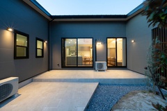 建物に囲まれた落ち着いたタイルデッキ。夜のライトアップが美しく、室内との調和が取れたデザインが魅力。