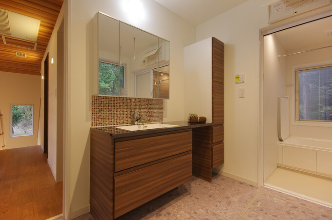 広々とした洗面スペースで、豊富な収納と大きな鏡が特徴的。バスルームへとつながっている配置で、動線も抜群である。