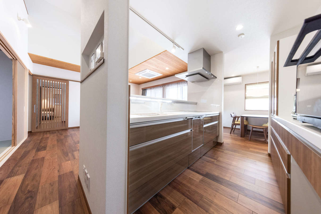 渡辺建設【デザイン住宅、夫婦で暮らす、平屋】キッチンを起点にぐるぐると回遊できる家事ラク動線。ニッチに設置したコントロールパネルで、玄関扉や駐車場ゲートを自動解錠できるので便利