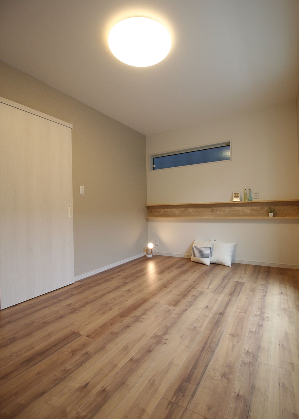 小野田産業～designers house project～【1000万円台、デザイン住宅、子育て】ベージュ系でコーディネートした癒しの寝室。ベッドのヘッドボード側には、床に合わせたクロスでデザインした棚も。本やスマホなど、ちょっとした小物を置ける
