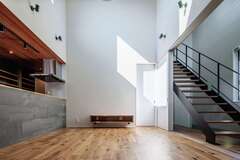 リビングに吹き抜けと大きな窓、さらにスケルトン階段を採用することで十分な光を取り込む、開放的な大空間が生まれた