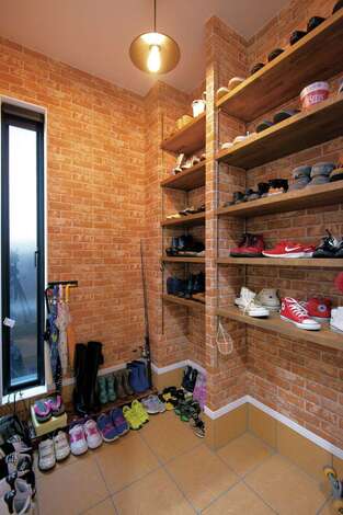 扉を付けずオープンにしたシューズインクローゼット。レンガ調のクロスを用いてブルックリンスタイルに。来客の目にも触れるので、ディスプレイ収納を意識