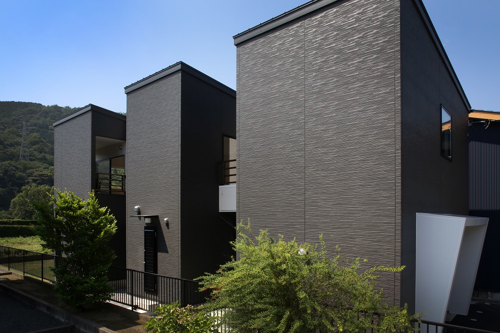 一級建築士事務所 GO_AN (ゴアン)【デザイン住宅、子育て、ガレージ】外観全景。光庭を挟むように3つの“箱”を配置。右下の白いボックスはガレージ入口の大庇。道路から見た外観デザインを“意識して整えている