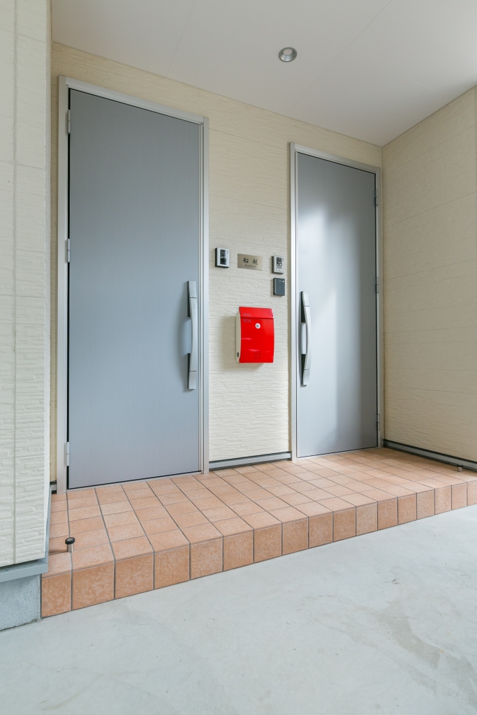 建築システム（狭小住宅専門店）【二世帯住宅、狭小住宅、ガレージ】二世帯のため、玄関ドアも２つ設置。真っ赤なポストが目をひく。都市型シンプルデザイン