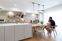 5人家族がゆったり集えるキッチンダイニング。明るいカウンタートップが気に入ったオープンキッチンは、前面の収納力も魅力。キッチン背面はスリット窓を飾り棚に変更してコストカット