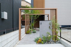 旗竿地の通路部分を活用した、庭のアプローチ。植物やアーチが出迎えてくれるおしゃれなデザイン。