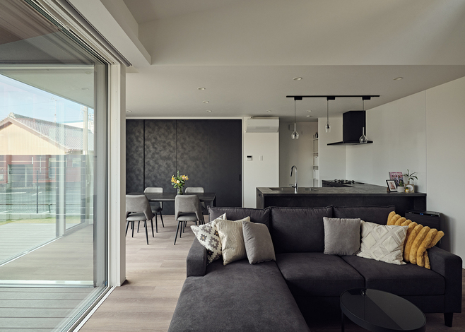 ソファでくつろぎながら、ドッグランを見渡せるリビング。LDKの床には、ホテルなどで使われるアスワン「ロボフロア」を採用。床を踏んだ感触が柔らかく、衝撃吸収性や防滑性にすぐれ、愛犬の足にやさしいのが特徴。メンテナンスもしやすく、愛犬との暮らしに最適だ