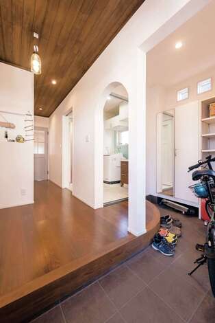 ホール側の垂れ壁はアーチにしてアクセントに。上がダイニングテーブルと併せて、ベンチシートも造作で。座面を上りかまちのアールも優しい雰囲気を醸し出している