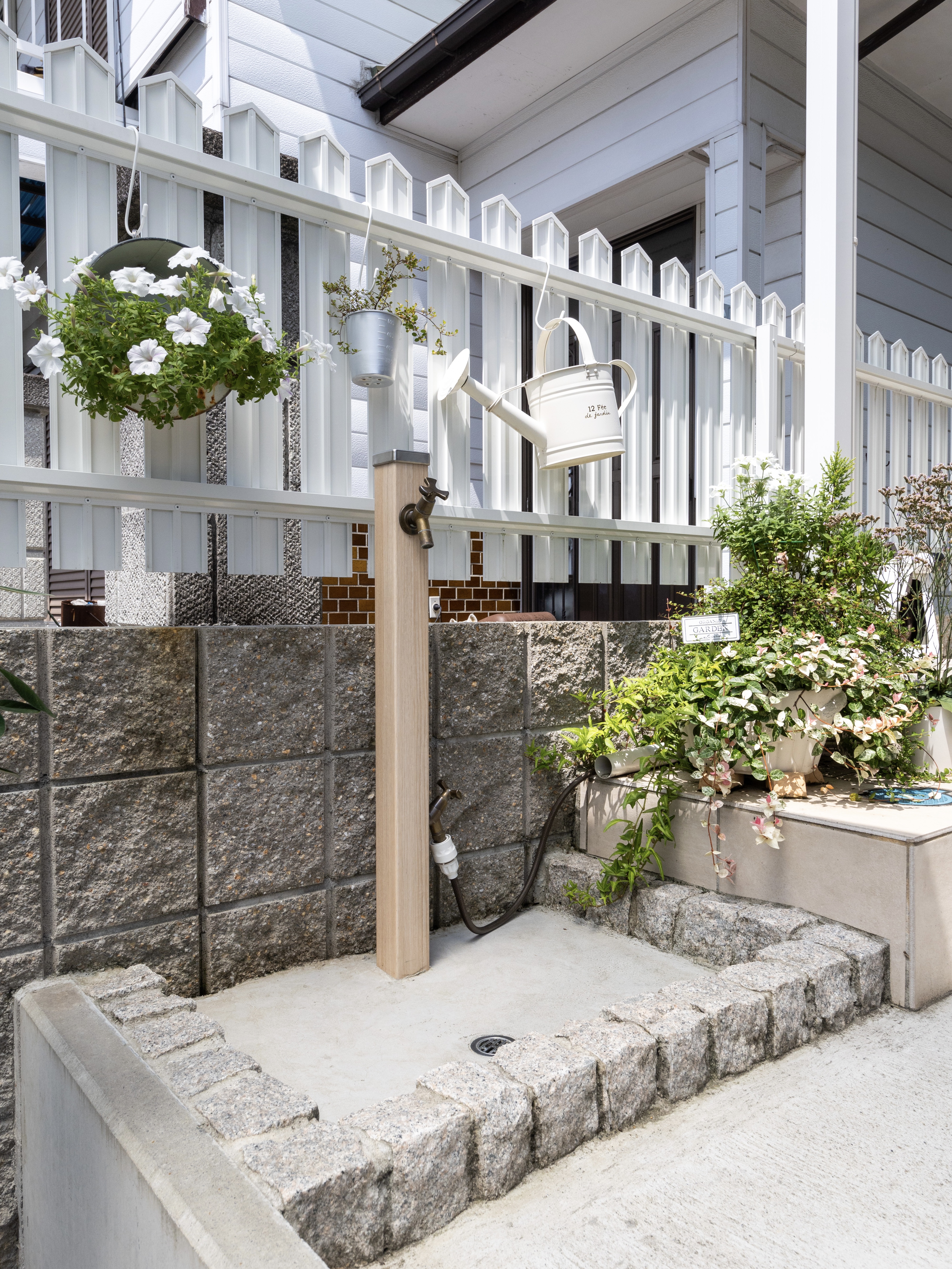 エスホーム｜自然と調和する小さな庭スペース。塀に沿って配置された植物が、落ち着いた雰囲気を演出している。