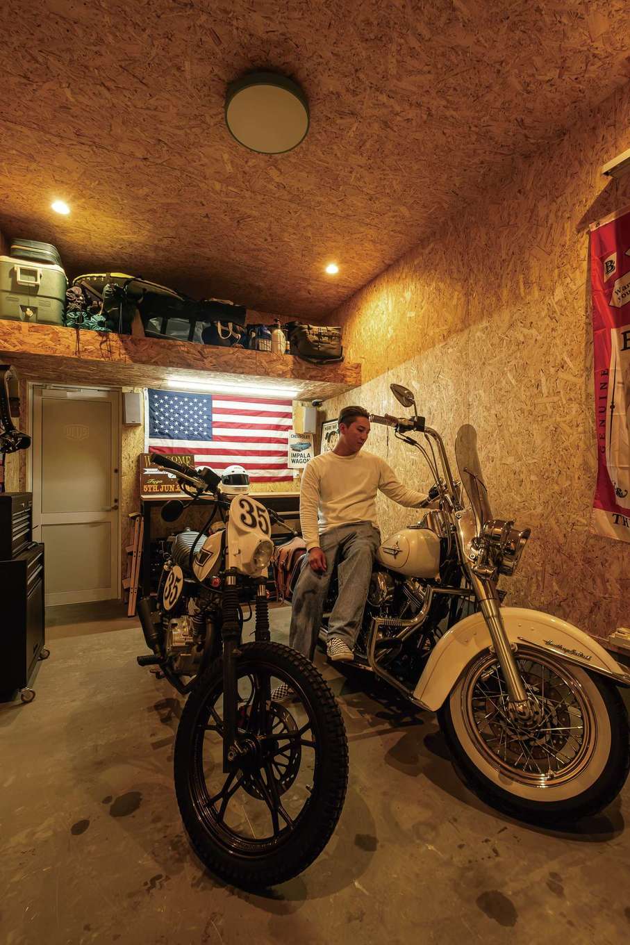 住起産業（アキュラホーム三島中店）｜ハーレーとオフロードバイクを格納するビルトインガレージ。OSB合板でワイルドに仕上げ、作業台とロフトも設置した。超アウトドア派のご主人は家にじっとしていられない性格だったのに、憧れの「男の隠れ家」ができたことで、休日は朝からこもってバイクいじりを楽しんでいる