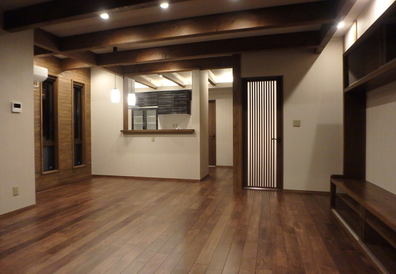 TDホーム静岡西 ウエストンホームズ【デザイン住宅、自然素材、間取り】梁が特徴的なリビングはTVボードを家全体の雰囲気に統一するよう造作。奥のキッチンからリビングを見ることができ、料理をしている奥さんも安心