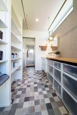 室内干しと収納スペース、作業用カウンターを設けたランドリー。勝手口の先にはデッキがあり、外干しも便利