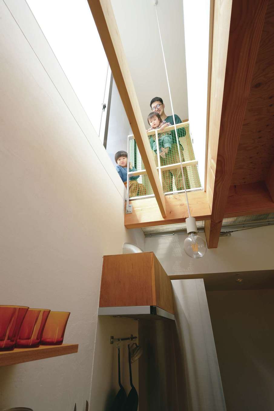 MABUCHI【デザイン住宅、狭小住宅、間取り】キッチンは吹抜けを通じて2階と繋がっている。「おーい、ママ」とお子さまが奥さまに声をかけたりと、常に家族が一体感を味わえる