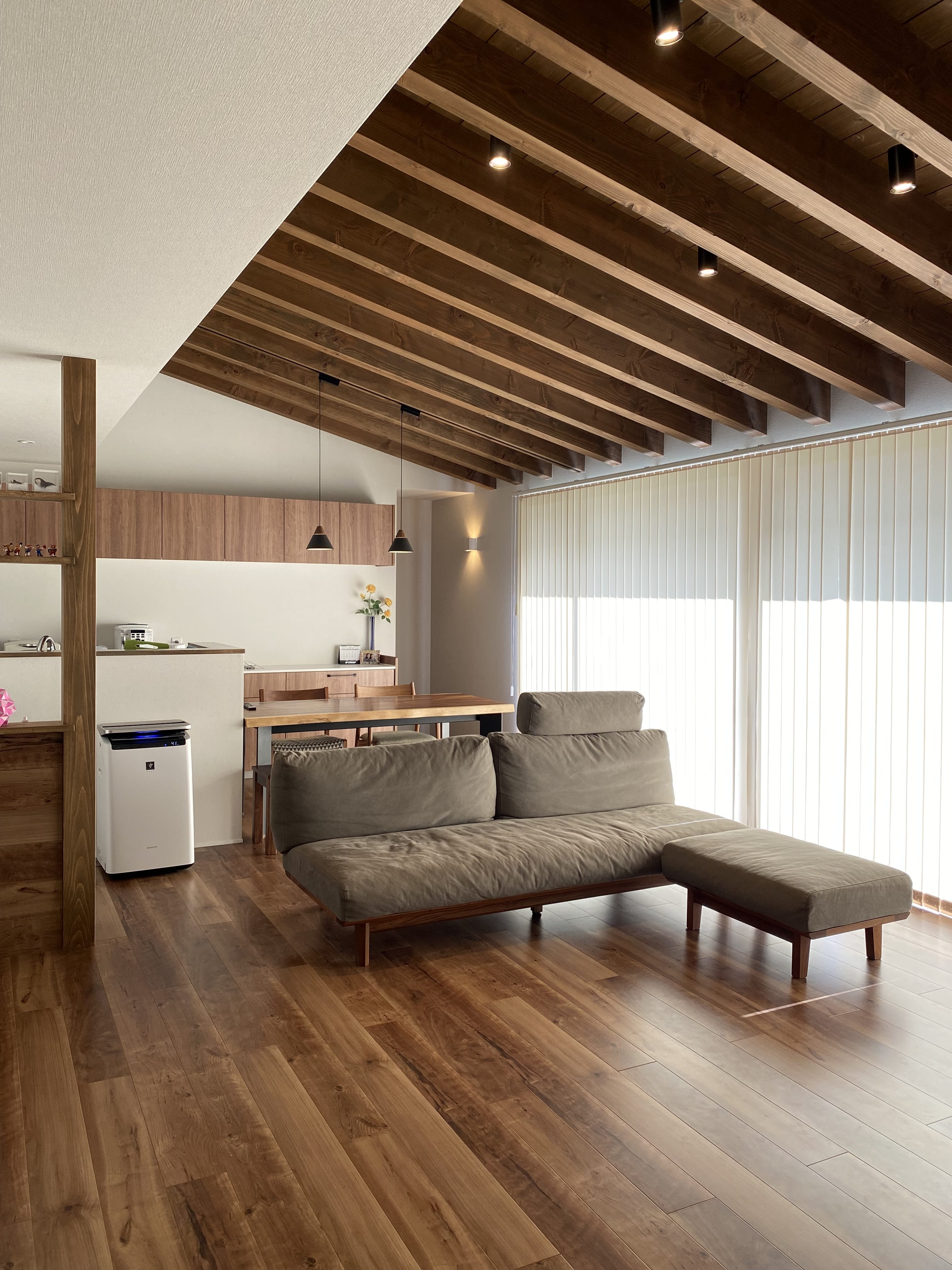 安田住宅｜安田建築設計室｜温かみのあるチェリーのフローリングと天井が特徴のLDK。大きな窓からたっぷりと光が差し込み、開放感がある心地よい空間である。ソファやダイニングテーブルの配置が工夫され、リビングとダイニングが一体となっている。