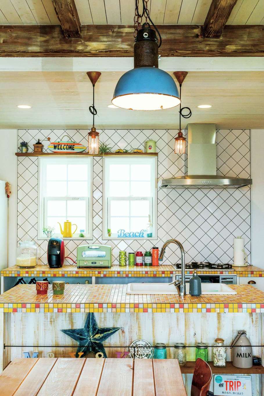 富士ホームズデザイン【デザイン住宅、建築家、インテリア】モザイクタイル貼りのキッチン、斜めに貼った壁のタイル、アンティーク照明、それぞれの個性が絶妙にマッチしたダイニング。「キッチンのモザイクタイルは私の好きな黄色をベースに、設計の上総専務がアクセントカラーをほどよくプラスしてくれたおかげで、こんなにオシャレに仕上がりました」と奥さまもにっこり