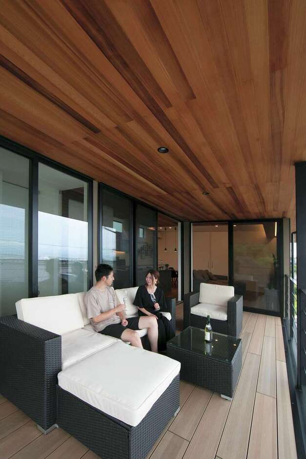 O邸のシンボルとも言える広いオープンデッキ。休日は遅い朝食をとったり、BBQを楽しんだりも。高台から見降ろす夜景も美しい。深い軒が夏の強い陽射しを遮り、太陽高度の低い冬は室内の奥まで光を届けてくれる