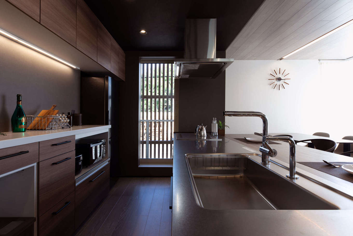 建築システム（狭小住宅専門店）【静岡市駿河区東新田3-2-27・モデルハウス】アイランドキッチンのキッチンカウンターは造作で。窓から透ける外観の縦格子がインテリアのアクセントにもなっている