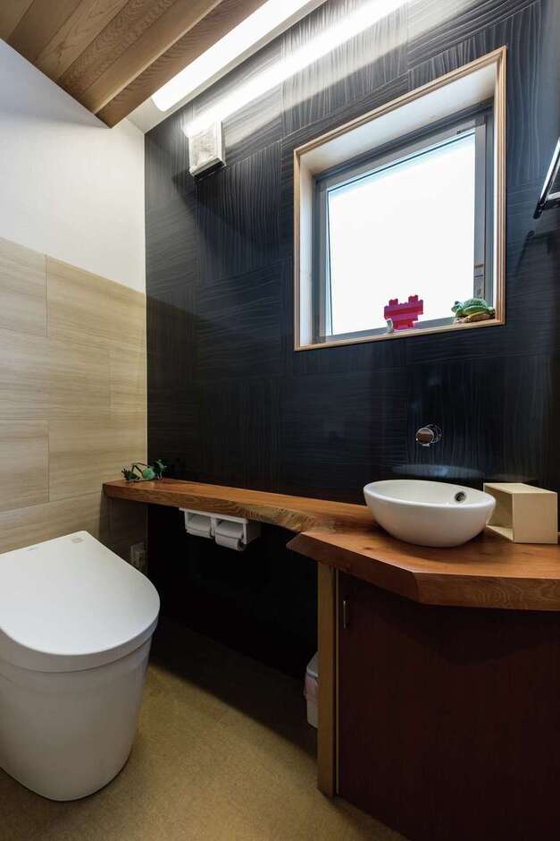トイレカウンターはケヤキの1枚板。スギのR天井と間接照明で落ち着きのあるトイレ