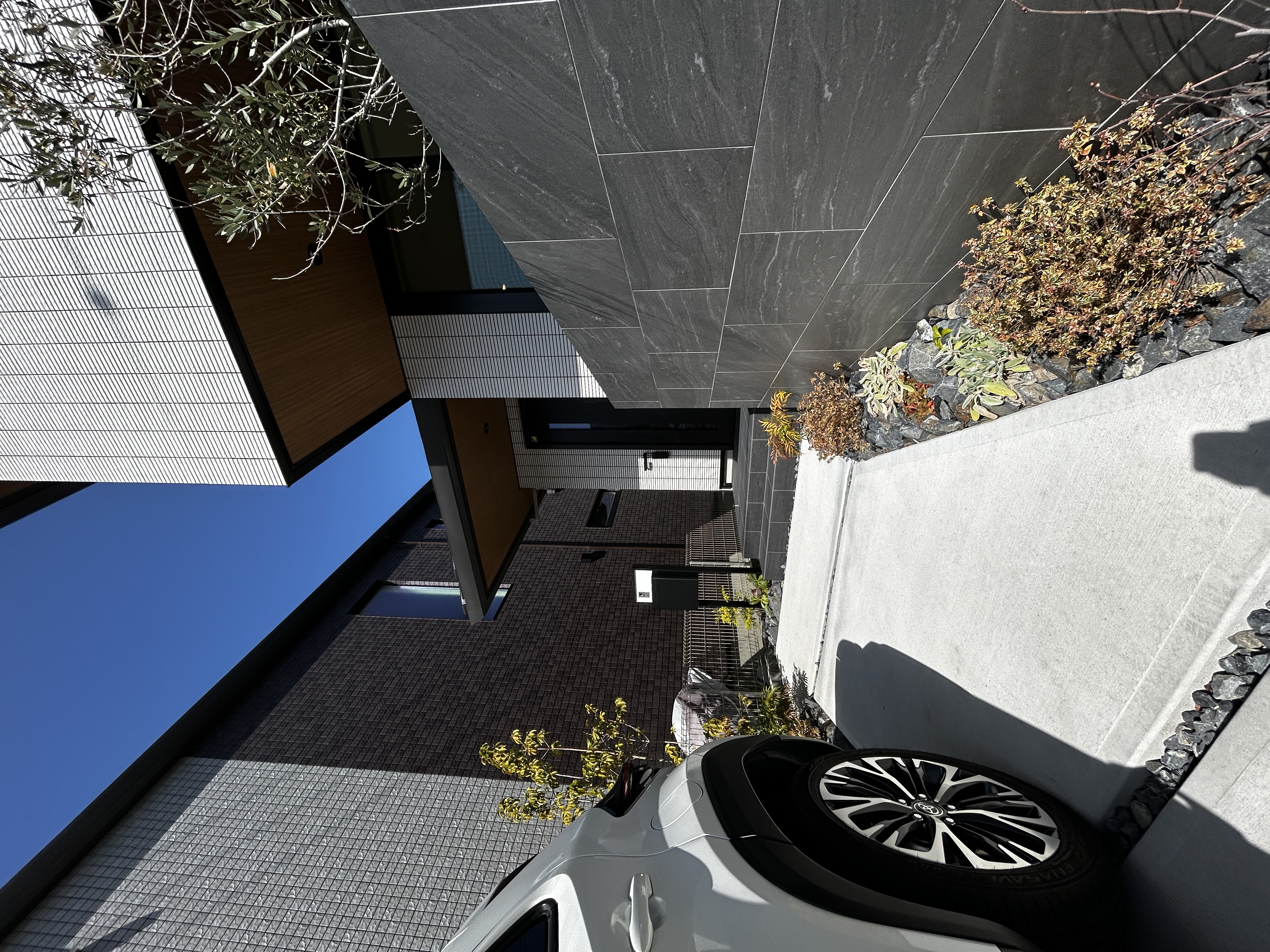 パナソニックホームズ中部第一支社 愛知第一支店・愛知第二支店｜モダンなデザインが特徴の住宅の外観。石材を使ったエントランスアプローチが高級感を演出し、住まいの品格を高めている。