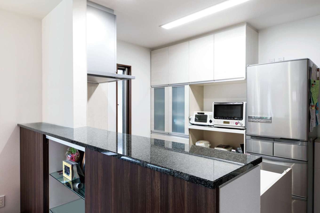 -delphi- デルフィ（藤井建築事務所） 【デザイン住宅、間取り、建築家】対面式キッチンにカウンターを造作。御影石の天板の下は収納になっており、A４サイズをしまえるサイズ。左右を姉弟それぞれが使用。絵本やおもちゃを自分で出して、遊んだ後は自分で片付ける習慣がついた