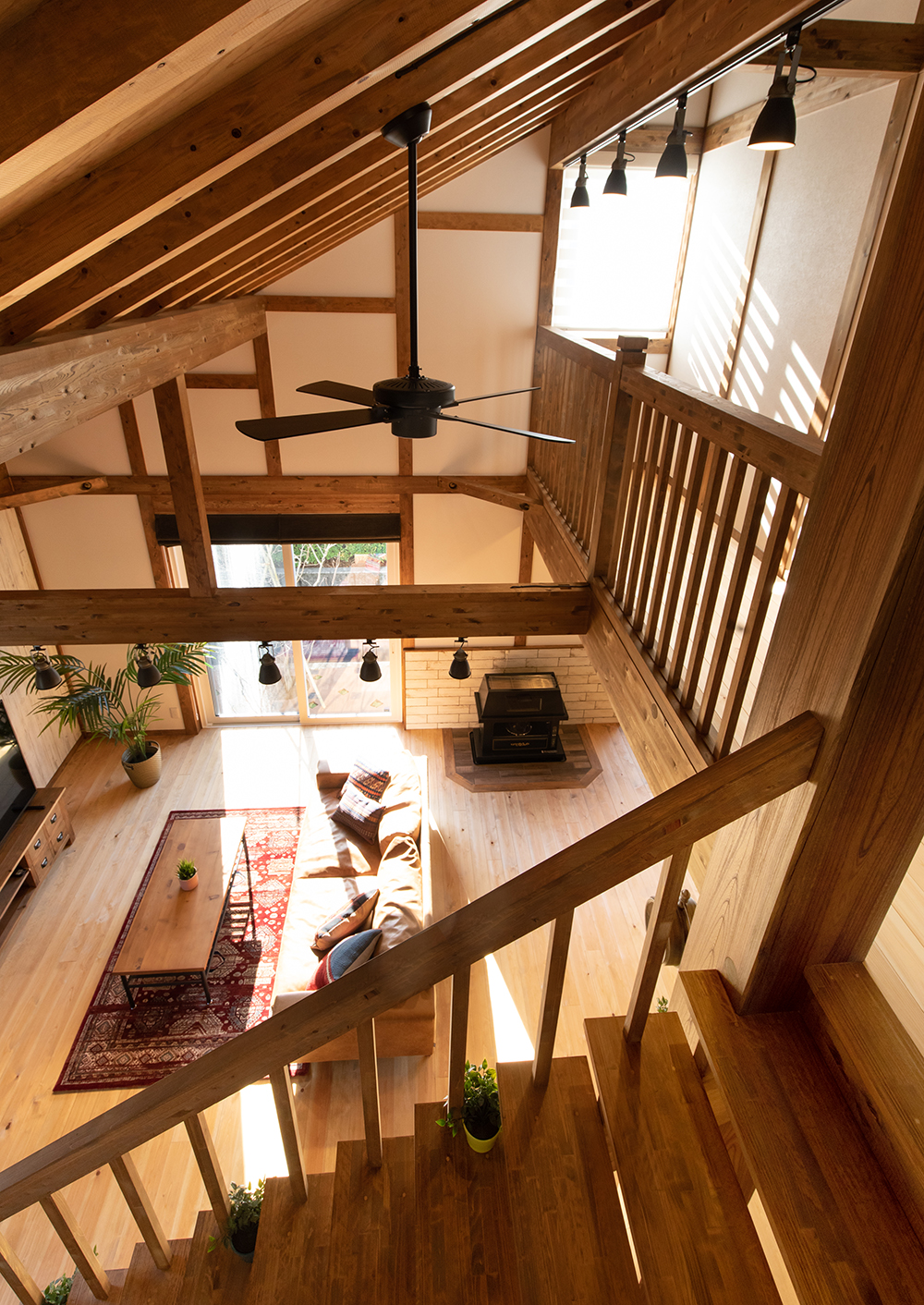 サイエンスホーム【静岡市葵区羽鳥本町4-32・モデルハウス】階段上部から見たリビングの景色。勾配天井の視覚的効果でいっそう広く感じられ、木のぬくもりとおおらかさに癒される極上の空間だ