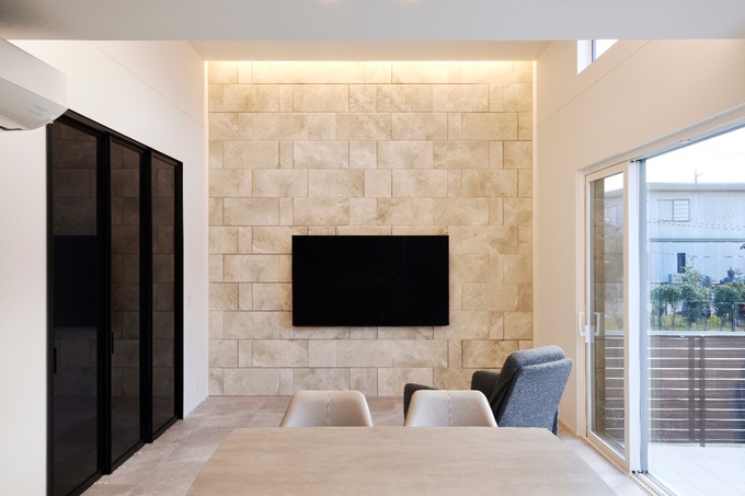 リビングのTV背面には全面大判エコカラットを使用し、愛犬と暮らす空間に調湿・消臭効果をプラス。上部からの間接照明が柔らかな光を与え、洗練された雰囲気を演出。