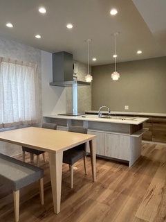 木の温もりを感じるLDK。オープンキッチンとダイニングテーブルが調和し、家族団らんの時間を豊かに演出する空間である。