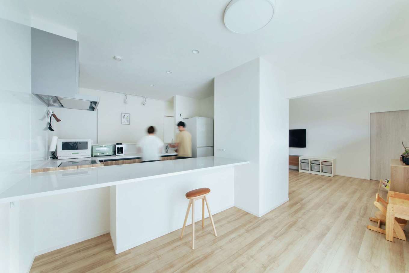 子育て安心住宅 Design Craft Office【デザイン住宅、趣味、平屋】「作る場所と食べる場所が一体化しているので、配膳や片付けがすごく便利です」と奥さま。造作のカウンター部分は、掃除がしやすい素材を採用した。リビングとキッチンの間にパントリーを設け、収納も十分に確保した
