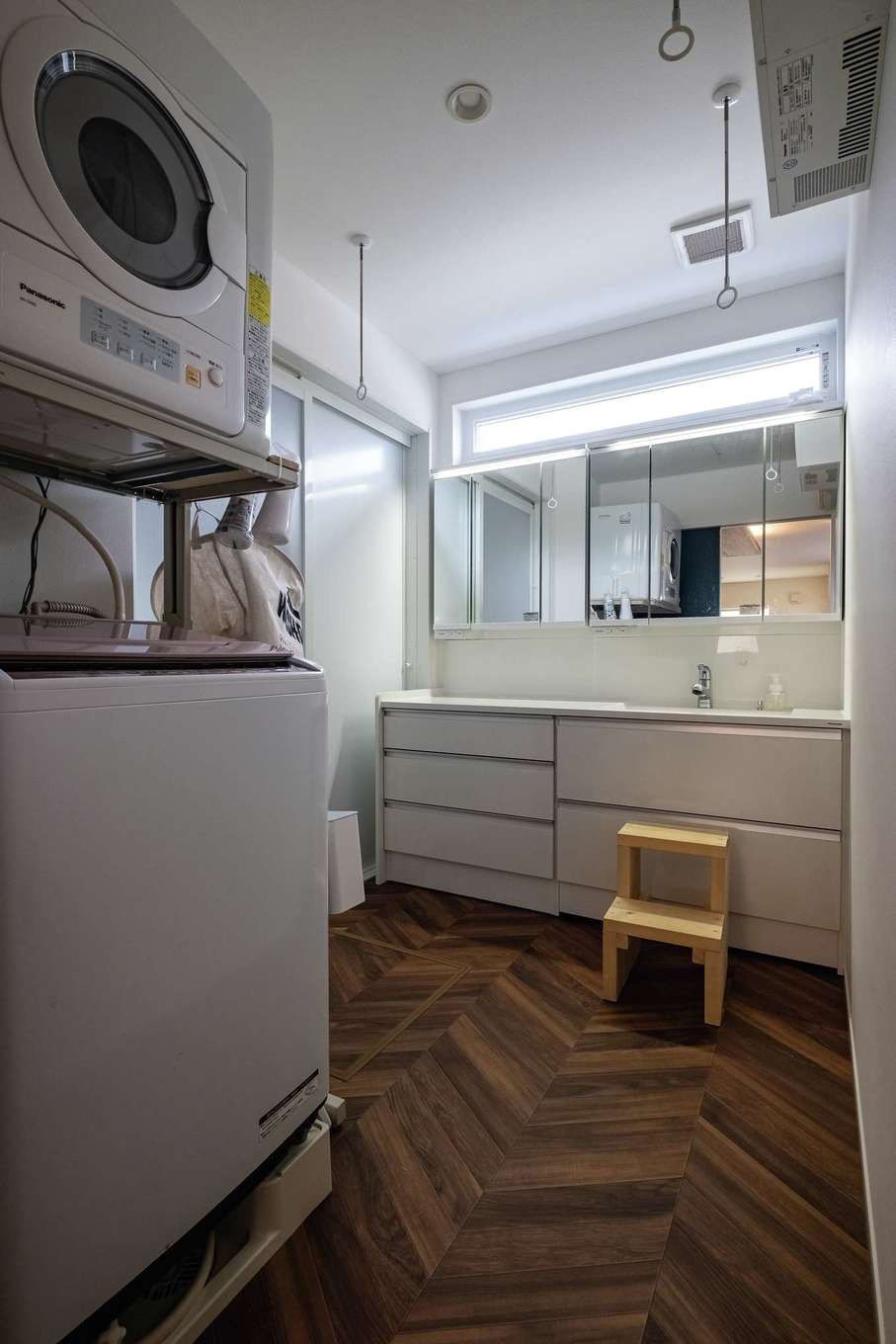 臼幸産業【デザイン住宅、省エネ、間取り】ヘリンボーン柄の床がおしゃれな洗面脱衣所。乾燥機は一年中活躍するがZEHのおかげで予想よりも光熱費がかからない