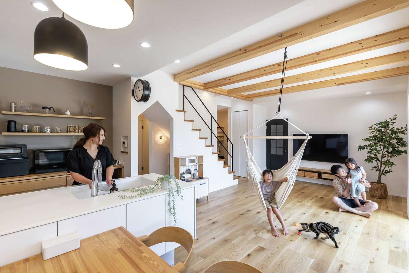 SEVEN HOUSE/セブンハウス【デザイン住宅、間取り、平屋】北欧＆ナチュラルテイストのLDK。リビングの梁を現しにして変化をつけた。日当たり抜群の立地環境を活かして窓を大きくとり、たっぷりの光と風を招き入れる。ネコも居心地がよさそうで、飼い主と一緒に家中をぐるぐると回遊している