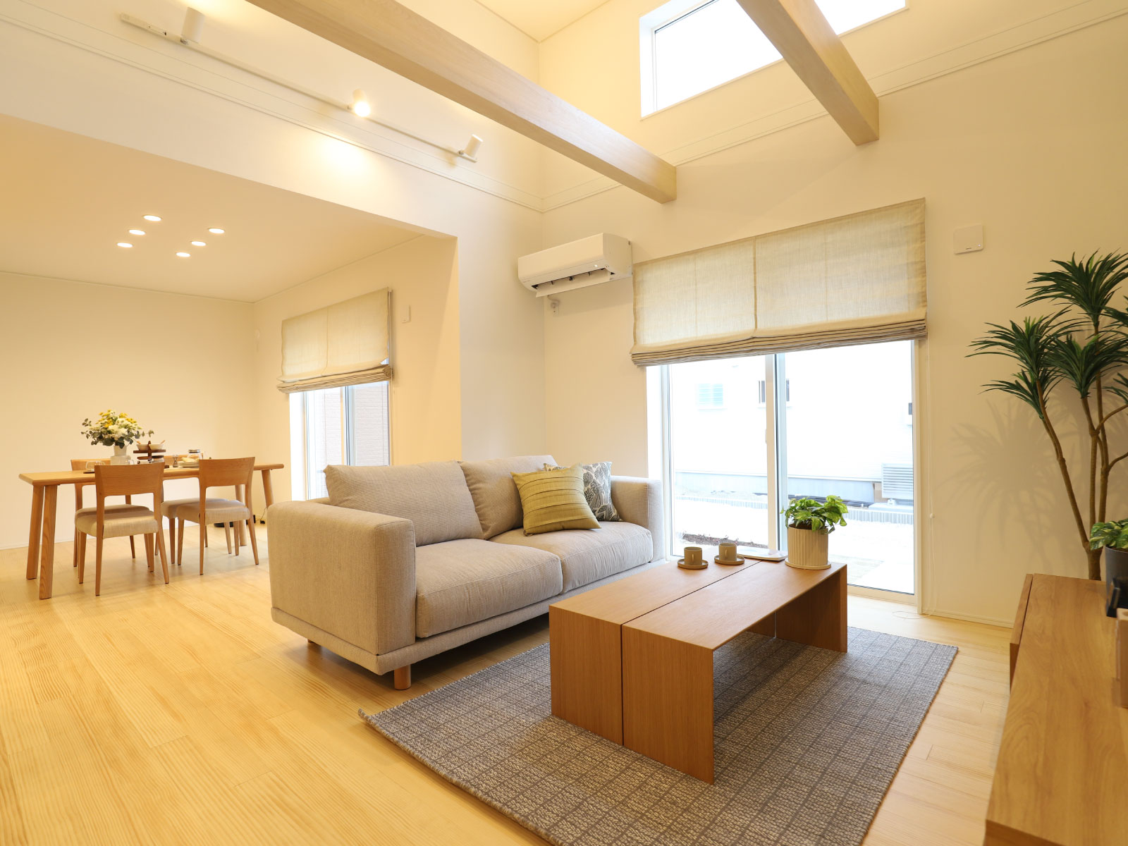 ヘスタホーム｜広々としたLDK。天井の梁がデザインアクセントとなり、ナチュラルなインテリアが居心地の良い空間を作り出している。