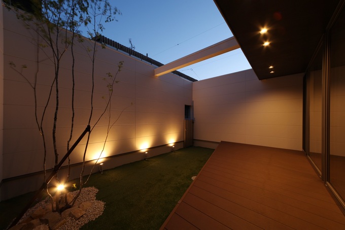 シンプルでありながら落ち着いた雰囲気を持つ中庭。照明が美しく映え、リラックスできる空間を提供する