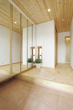 一般家庭の3倍はありそうな大きな姿見付きのシューズクローク。奥さまがインテリア雑誌でひと目惚れした事例を鈴木社長に見せて造作してもらった。玄関ホールの収納庫は家族やゲストのコートや上着を架けるときに使う。内装ももちろん無垢材！